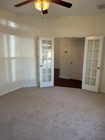 a view of an empty room with wooden floor and windows