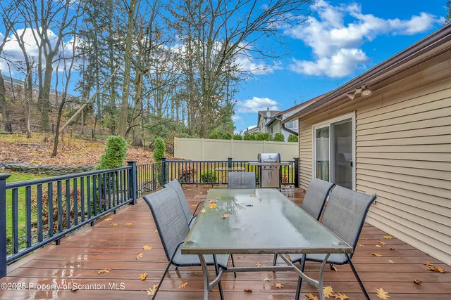 a view of a patio with table and chairs with wooden floor and fence