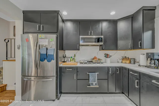 a kitchen with kitchen island a refrigerator and a sink