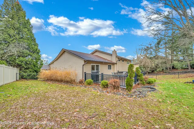 a view of a house with a big yard and large tree