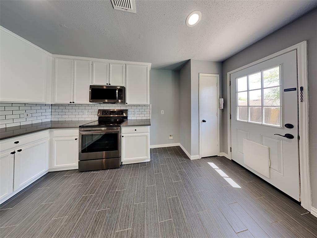 3808 Bandera Ranch Road Fort Worth, TX 76262 - Photo 4 of 15 a kitchen with stainless steel appliances a stove top oven and a refrigerator