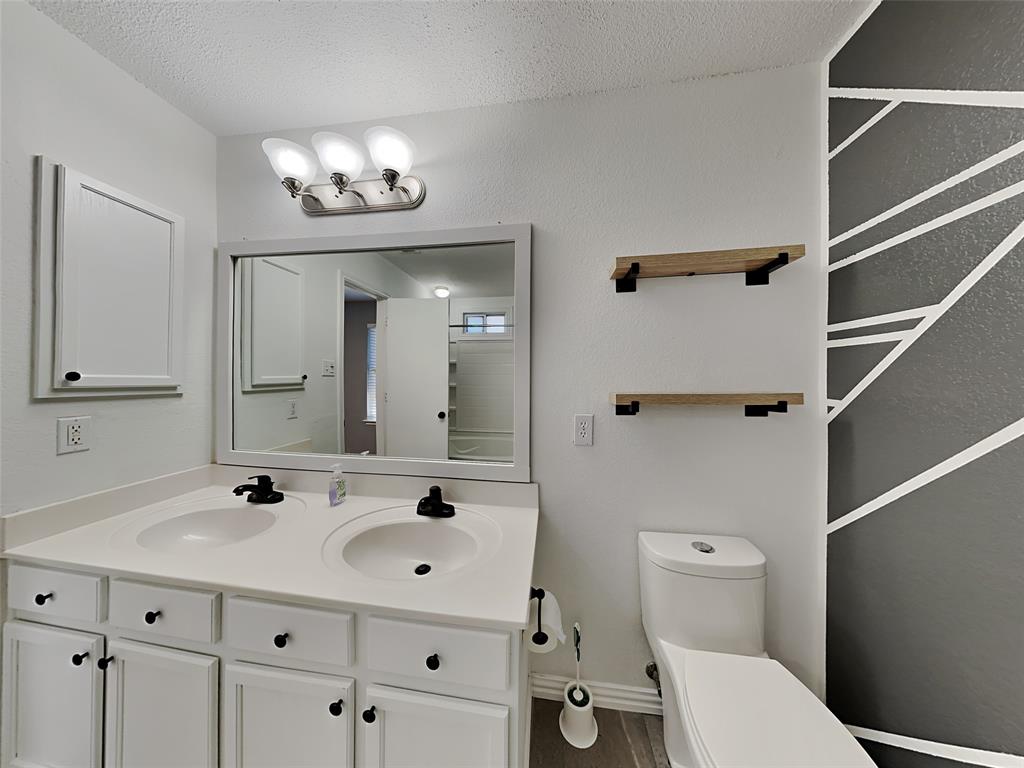 3808 Bandera Ranch Road Fort Worth, TX 76262 - Photo 8 of 15 a bathroom with a sink a toilet and a mirror