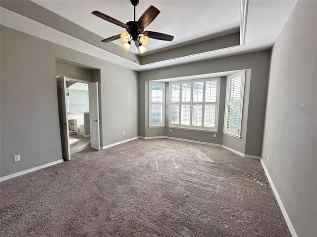 an empty room with a ceiling fan and a window