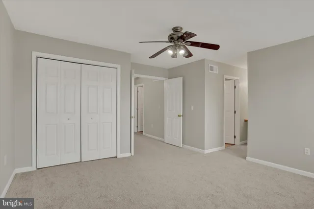 a view of an empty room and chandelier fan