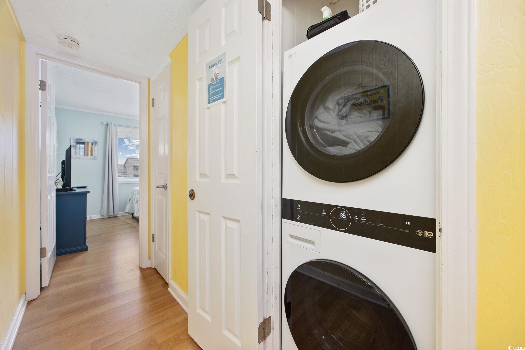 720 North Waccamaw Drive, Unit 301 Murrells Inlet, SC 29576 - Photo 13 of 37 Laundry room with stacked washer / dryer, light wood finished floors, and crown molding