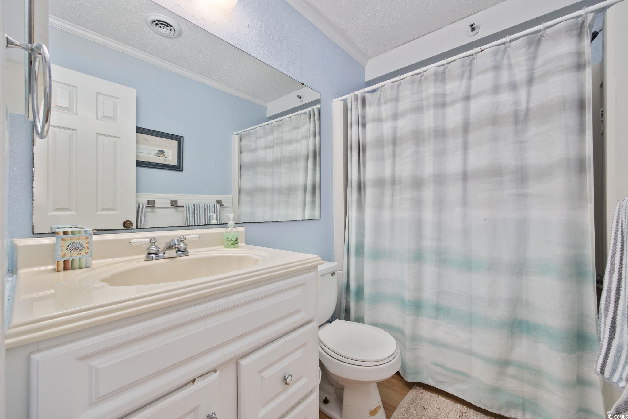 720 North Waccamaw Drive, Unit 301 Murrells Inlet, SC 29576 - Photo 16 of 37 Full bath with crown molding, vanity, and wood finished floors