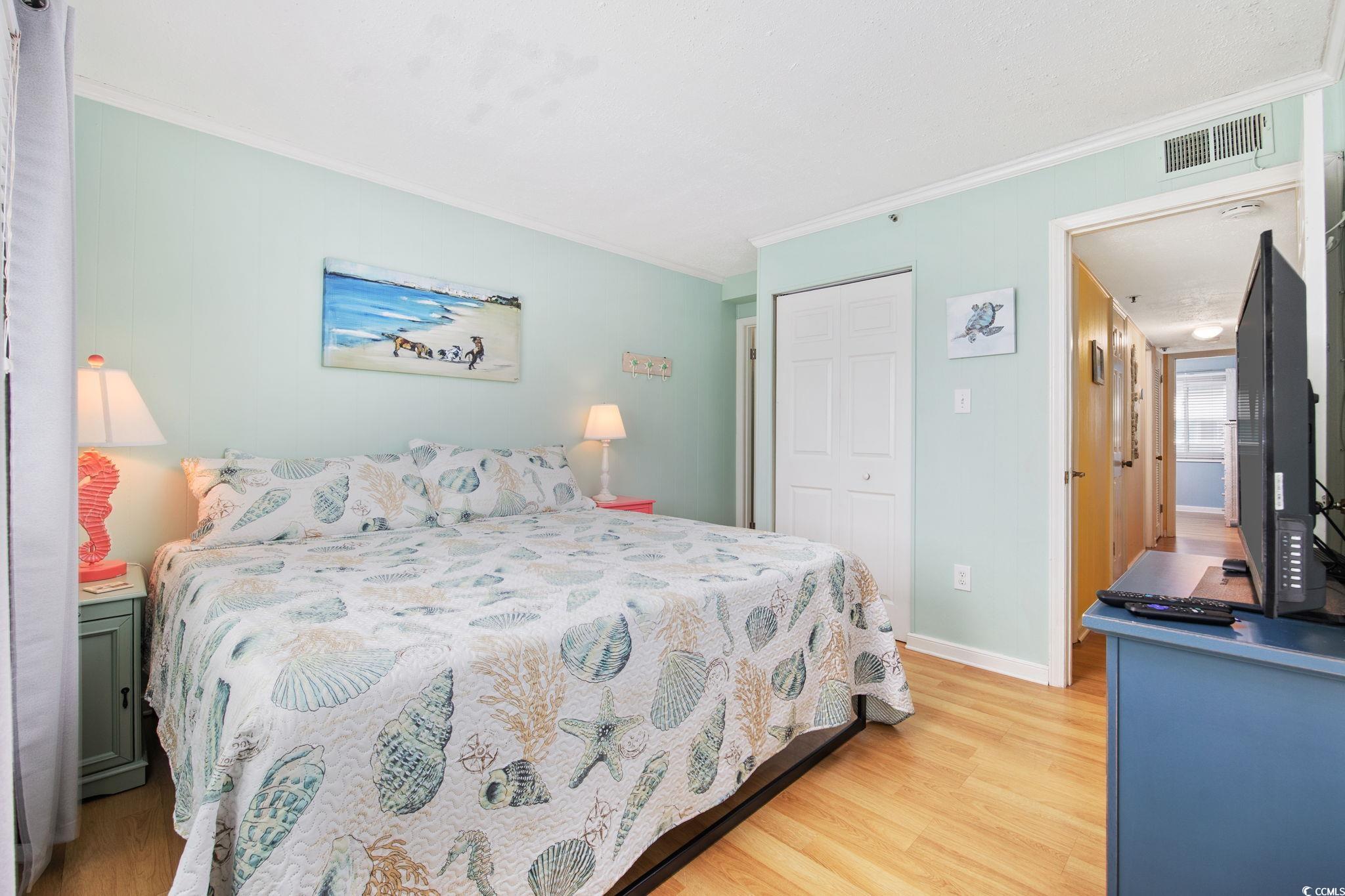 720 North Waccamaw Drive, Unit 301 Murrells Inlet, SC 29576 - Photo 18 of 37 Bedroom featuring light wood-type flooring, ornamental molding, and a closet