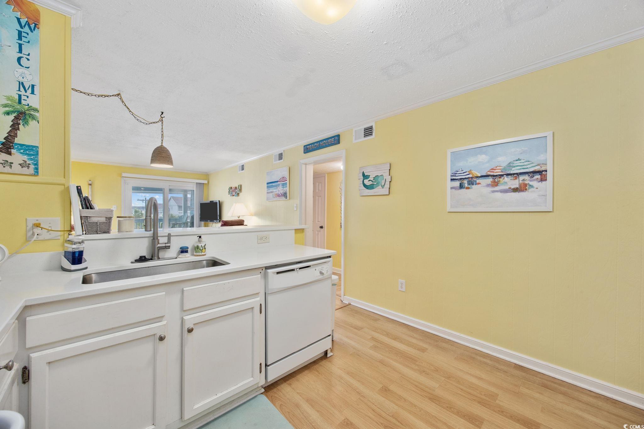 720 North Waccamaw Drive, Unit 301 Murrells Inlet, SC 29576 - Photo 5 of 37 Kitchen with light wood-style floors, dishwasher, white cabinets, a peninsula, and ornamental molding