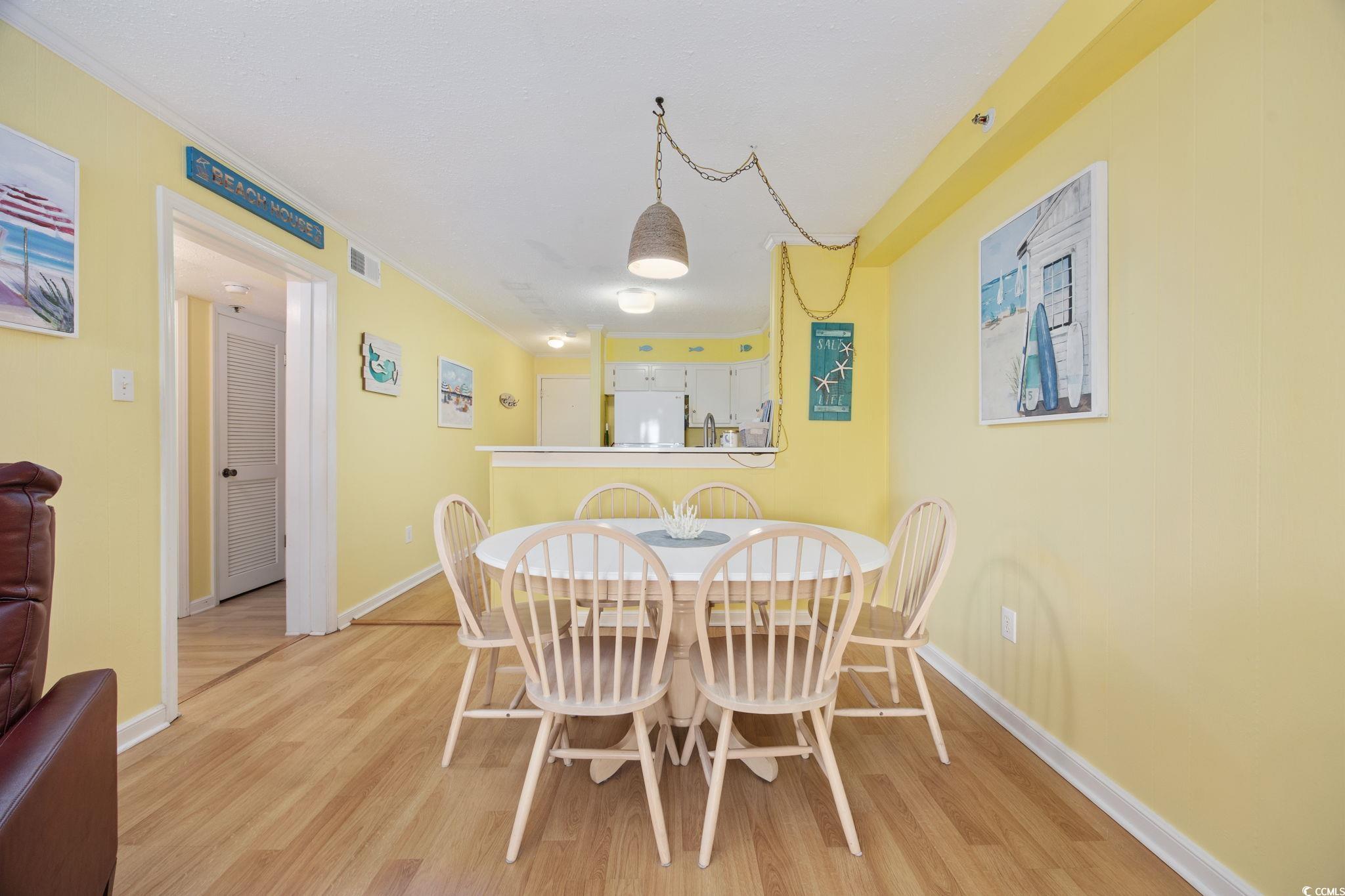 720 North Waccamaw Drive, Unit 301 Murrells Inlet, SC 29576 - Photo 6 of 37 Dining space with light wood finished floors and crown molding