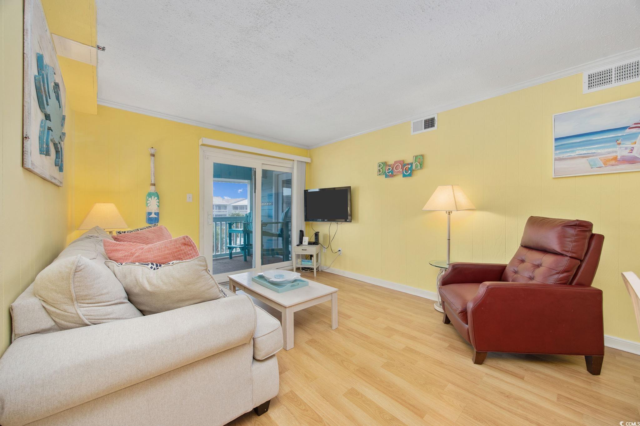 720 North Waccamaw Drive, Unit 301 Murrells Inlet, SC 29576 - Photo 10 of 37 Living room with wood finished floors, crown molding, and a textured ceiling