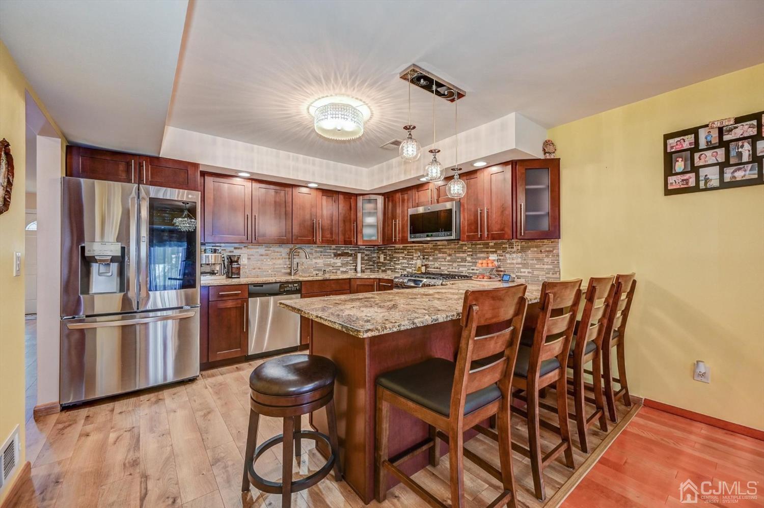 136 Redpine Loop Old Bridge, NJ 08857 - Photo 6 of 31 a kitchen with stainless steel appliances kitchen island granite countertop a refrigerator and microwave