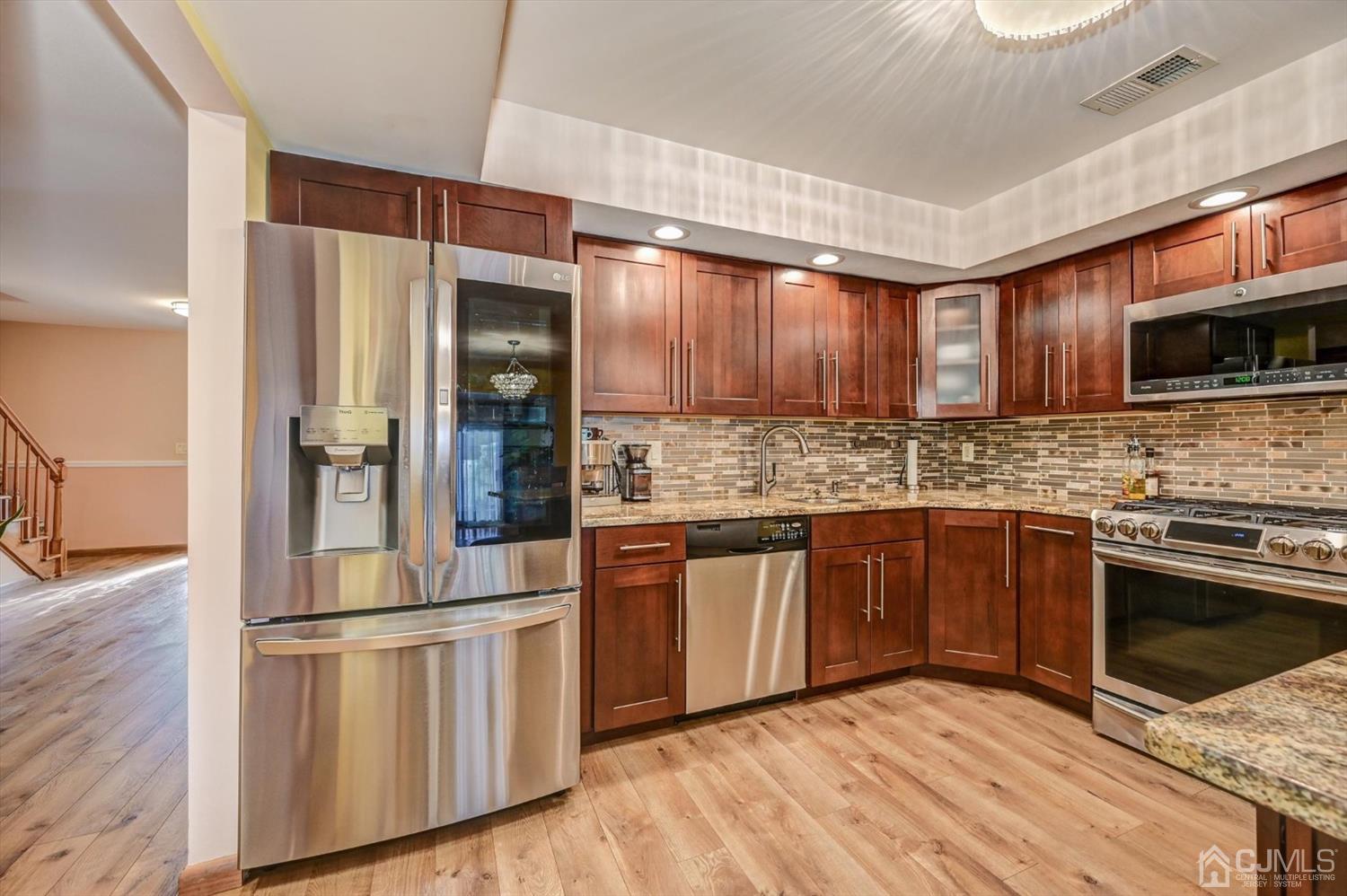 136 Redpine Loop Old Bridge, NJ 08857 - Photo 7 of 31 a kitchen with stainless steel appliances kitchen island granite countertop a stove a sink and a refrigerator