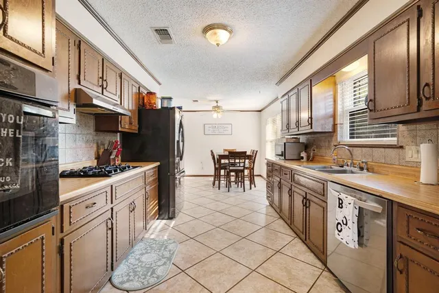 a kitchen with stainless steel appliances granite countertop a stove a sink dishwasher and a refrigerator