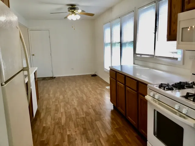 a kitchen with granite countertop a stove a sink and a refrigerator