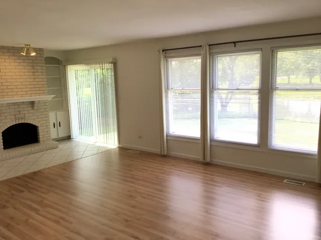 a view of empty room with wooden floor and fireplace