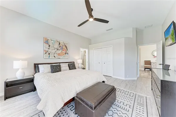 a bedroom with a bed a rug and wooden floor