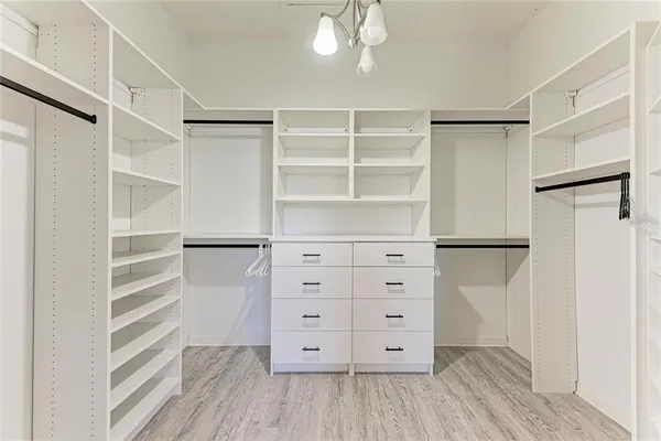 a view of walk in closet with empty racks