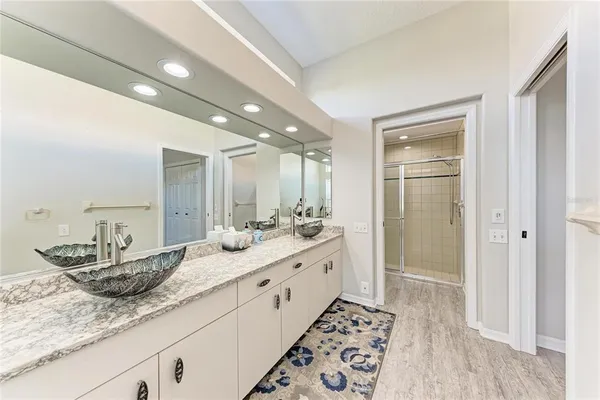 a bathroom with double vanity and a mirror