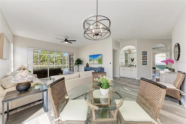 a living room with furniture chandelier and a large window