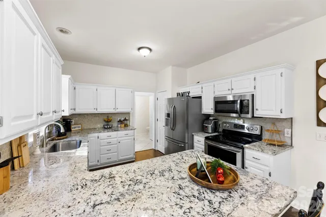 a kitchen with a refrigerator and a stove top oven
