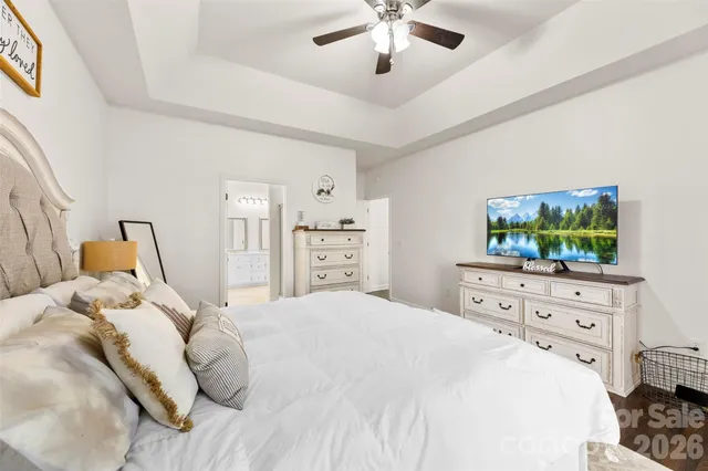 a bedroom with a bed and a flat tv screen on dresser