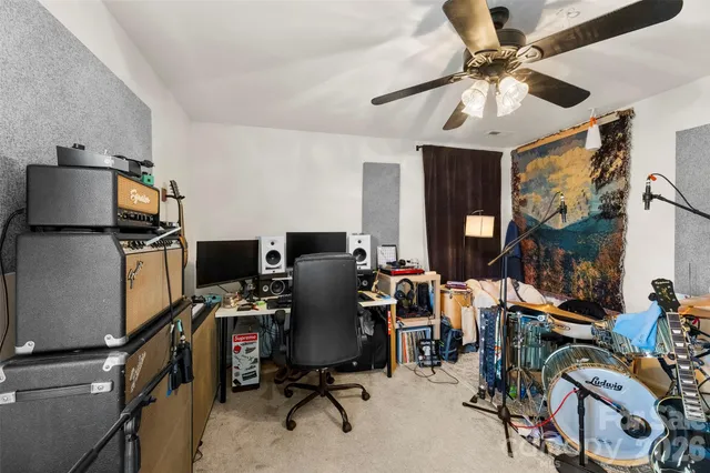 a view of a workspace with furniture and a ceiling fan