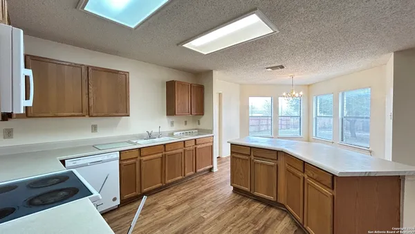 a large kitchen with stainless steel appliances granite countertop a sink and cabinets with wooden floor