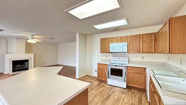 a kitchen with a sink stove top oven and refrigerator