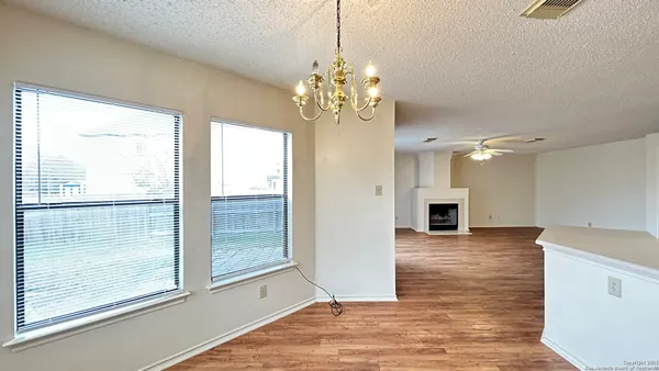 a view of a hallway with chandelier and wooden floor