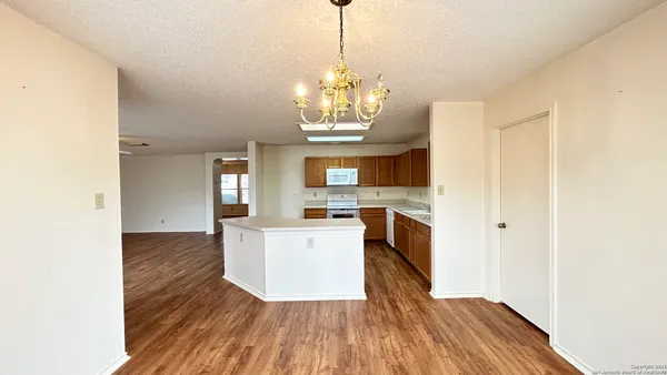 a view of a kitchen with wooden floor and electronic appliances