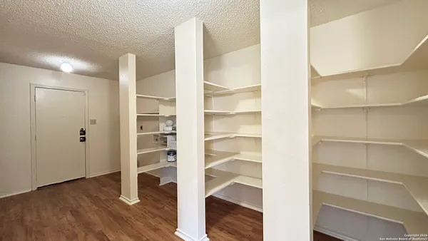 a view of walk in closet with empty racks
