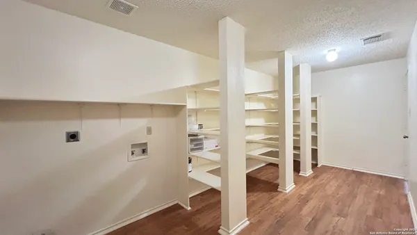a view of walk in closet with empty racks