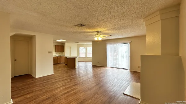 a view of a hallway with wooden floor and a kitchen