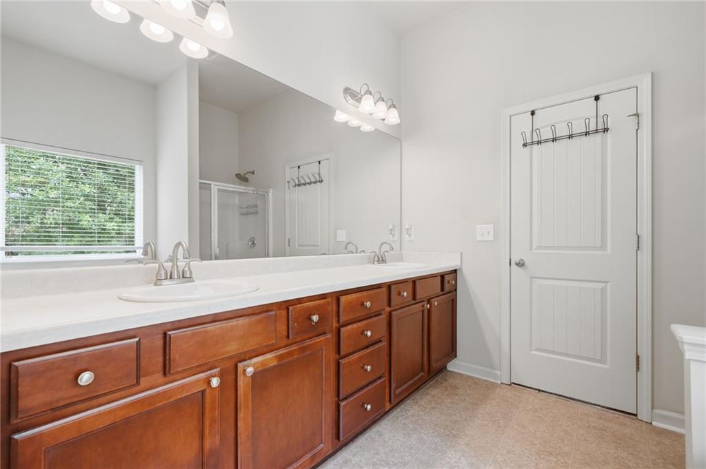 123 Renford Road Ball Ground, GA 30107 - Photo 16 of 27 a spacious bathroom with a double vanity sink a large mirror and a shower