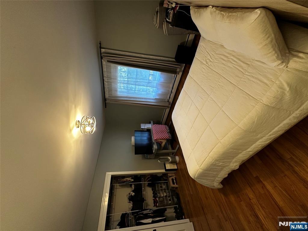 4 Rea Ave Extension, Unit 1 Hawthorne, NJ 07506 - Photo 13 of 18 a bedroom with a large bed and wooden floor