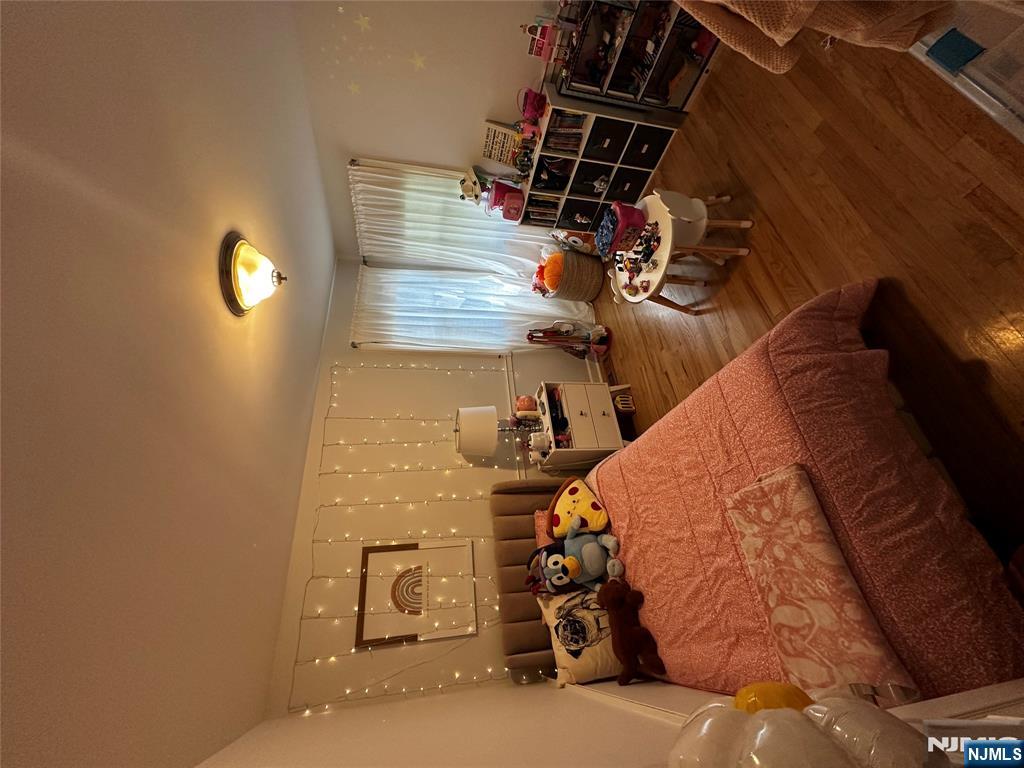 4 Rea Ave Extension, Unit 1 Hawthorne, NJ 07506 - Photo 14 of 18 a bedroom with furniture and a wooden floor