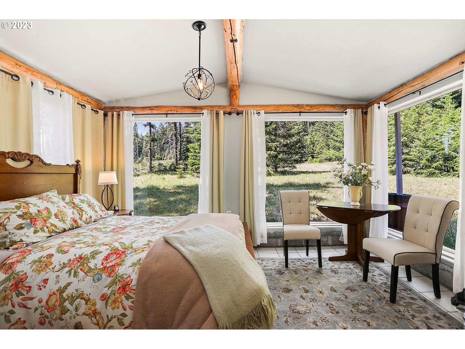 21 Prairie Road Appleton, WA 98602 - Photo 33 of 39 a bedroom with a bed a chandelier and a large window