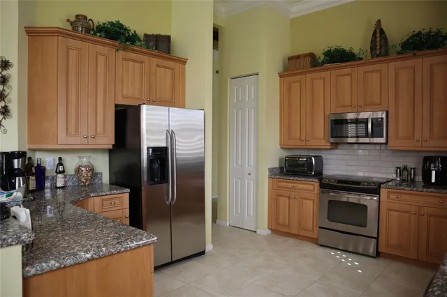a kitchen with stainless steel appliances granite countertop a refrigerator stove and microwave