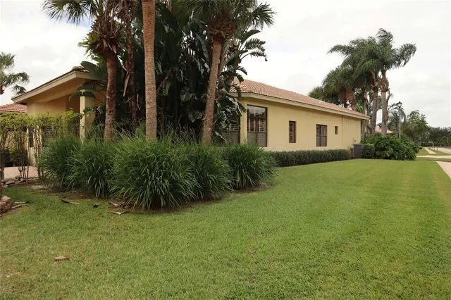 a view of a patio with table and chairs potted plants and floor to ceiling window