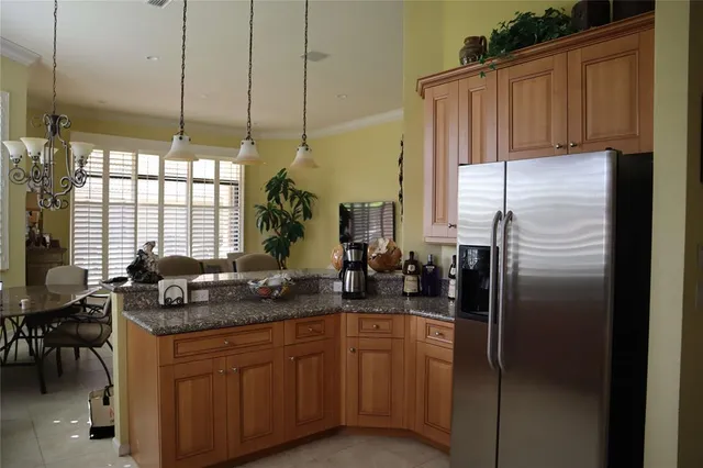 a kitchen with stainless steel appliances granite countertop a refrigerator a sink a stove and island