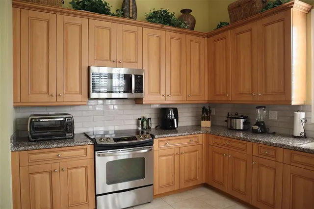 a kitchen with granite countertop white cabinets and stainless steel appliances