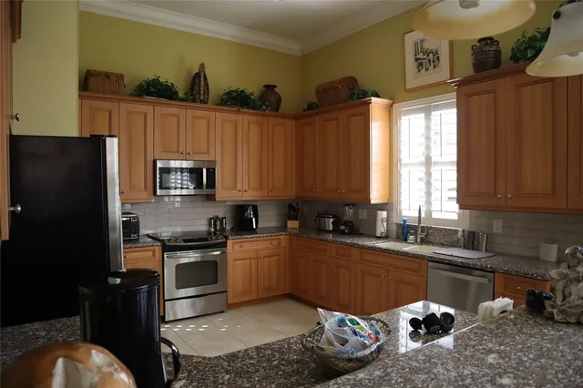 a kitchen with stainless steel appliances granite countertop a sink stove and refrigerator