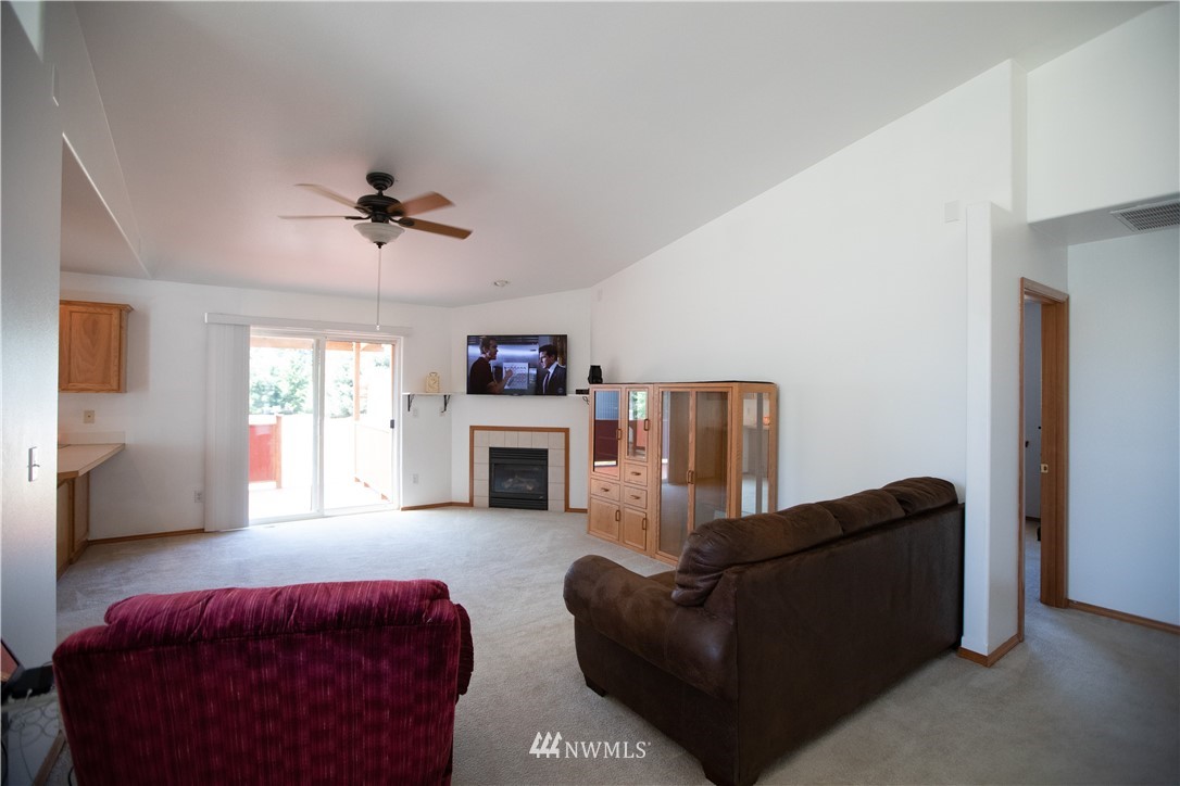 4129 Coomer Lane Southwest Rochester, WA 98579 - Photo 19 of 31 a living room with furniture a ceiling fan a fireplace and a window