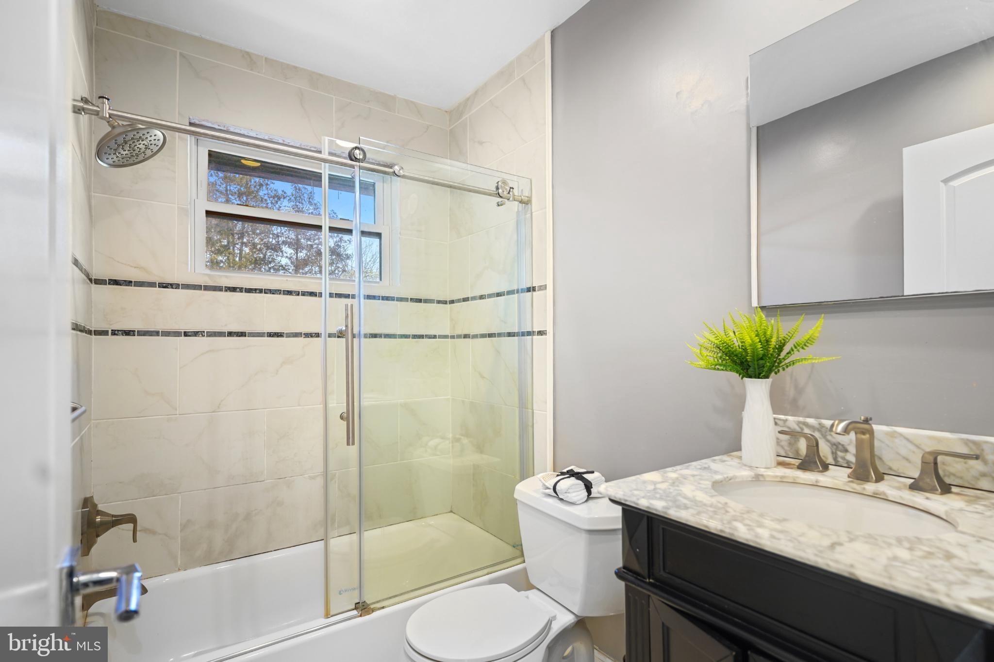 1790 Verbena Street Northwest Washington, DC 20012 - Photo 19 of 31 a bathroom with a granite countertop sink toilet a mirror and shower