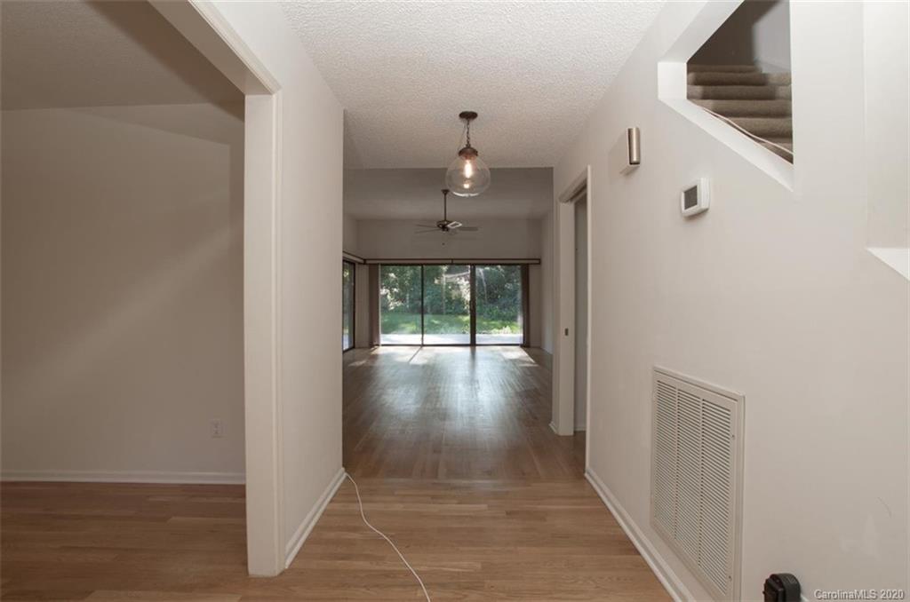 5220 Rounding Run Road, Unit 159 Charlotte, NC 28277 - Photo 22 of 42 a view of a hallway to an empty room with wooden floor and a floor to ceiling window
