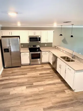a large kitchen with stainless steel appliances kitchen island granite countertop a sink and cabinets