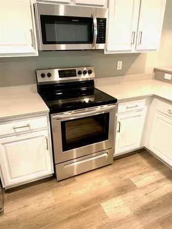 a kitchen with granite countertop a stove and a microwave