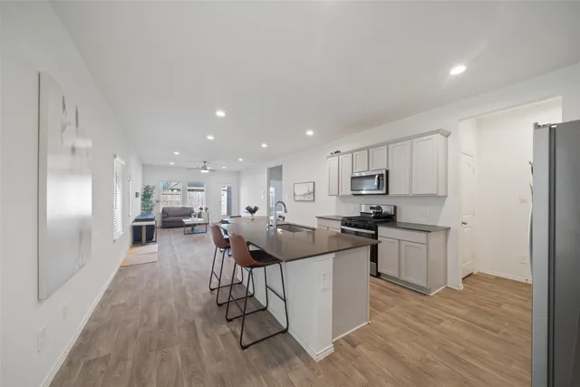 a kitchen with stainless steel appliances kitchen island granite countertop a sink and cabinets