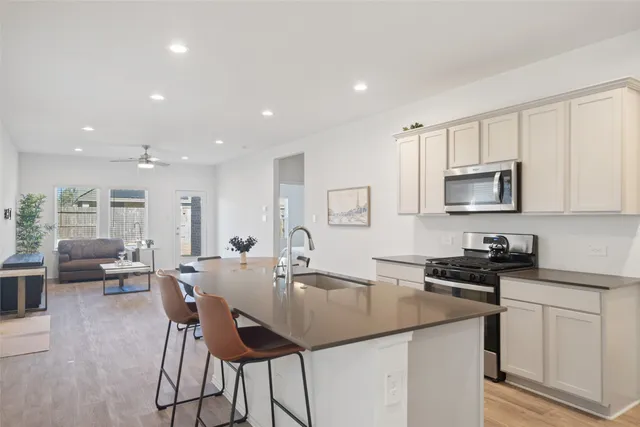 a kitchen with a sink stainless steel appliances and white cabinets