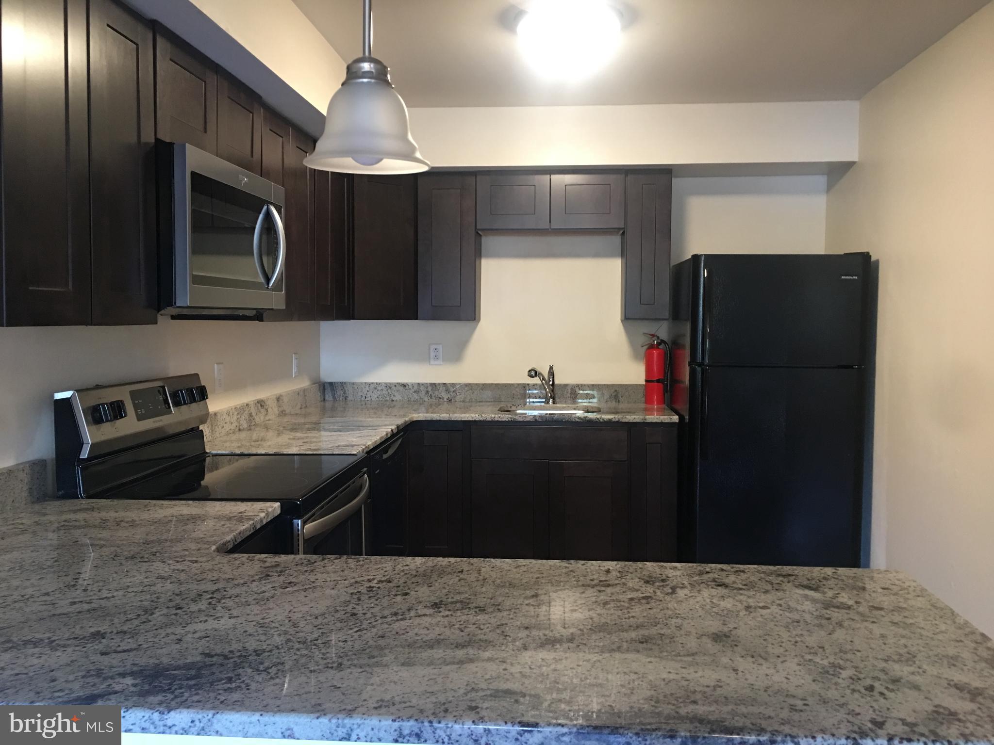 1 Pennsylvania Road, Unit 8 Glassboro, NJ 08028 - Photo 32 of 37 a kitchen with granite countertop a refrigerator and a stove